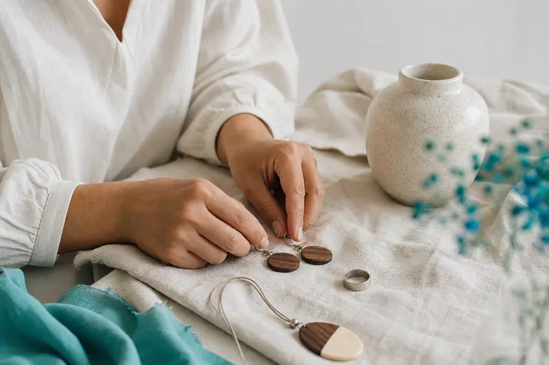 Bijoux en bois en noyer et érable posés sur du lin clair