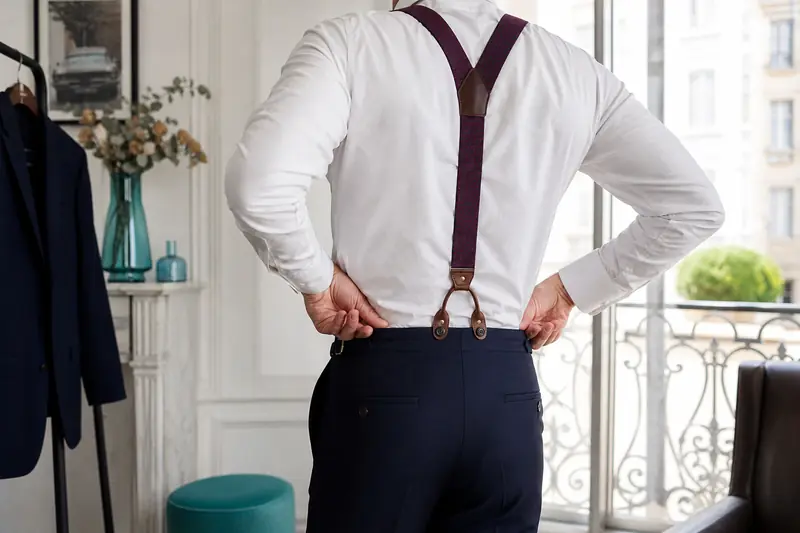 Bretelles fantaisie bordeaux portées avec un costume bleu marine et chemise blanche