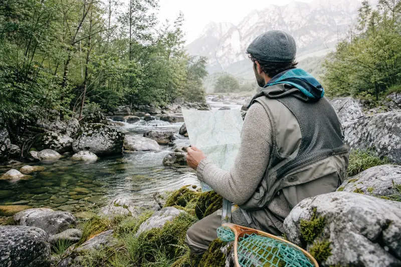 Pêcheur préparant sa carte rivière à truite au bord d’un torrent français