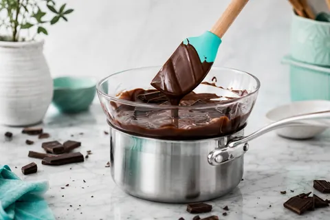 Bol de chocolat noir en train de fondre au bain-marie avec une spatule en silicone