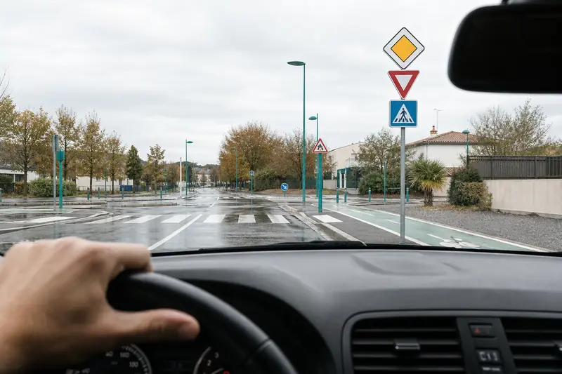 Conductrice observant plusieurs panneaux de signalisation à une intersection française
