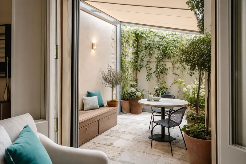 Terrasse végétalisée avec coin repas d’une maison de ville aménagée.