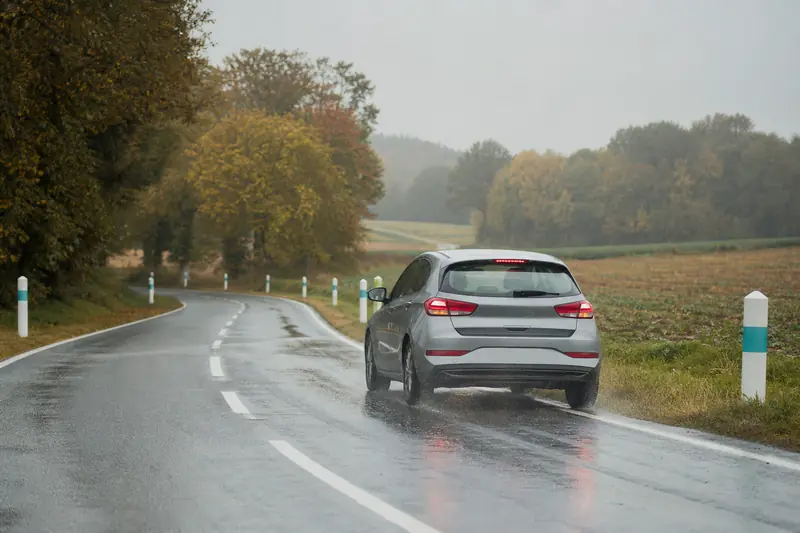 Voiture freinant sur route mouillée pour illustrer la distance d’arrêt.