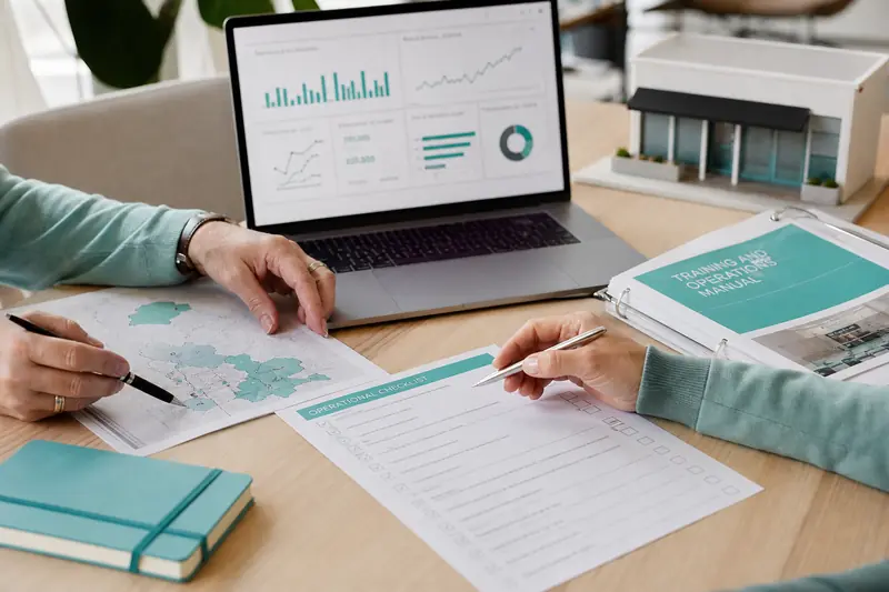 Deux entrepreneurs préparent le développement d’un réseau de franchise autour d’un plan.