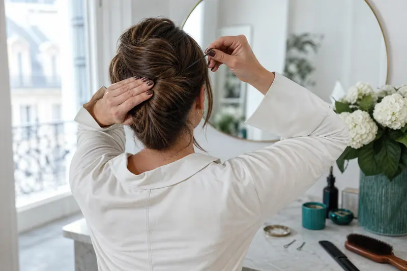 Réalisation d’un chignon banane avec épingles sur cheveux mi-longs.
