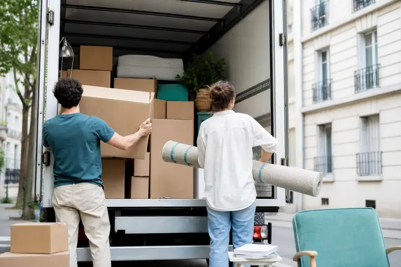 Organisation d’un déménagement économique avec cartons et utilitaire devant un immeuble résidentiel