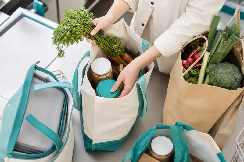 Rangement de courses dans un chariot de supermarché avec sacs séparés