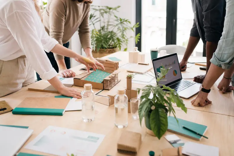 Équipe en hackathon écologique travaillant sur des prototypes réemployables en entreprise