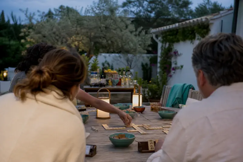 Soirée jeux de société en plein air sur une terrasse éclairée.