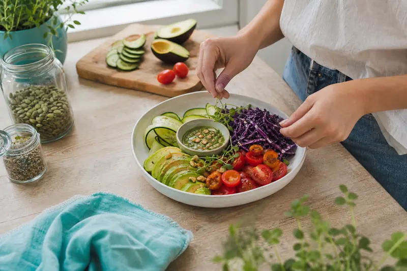 Préparation d’un menu tout cru vegan avec légumes frais, avocat et graines