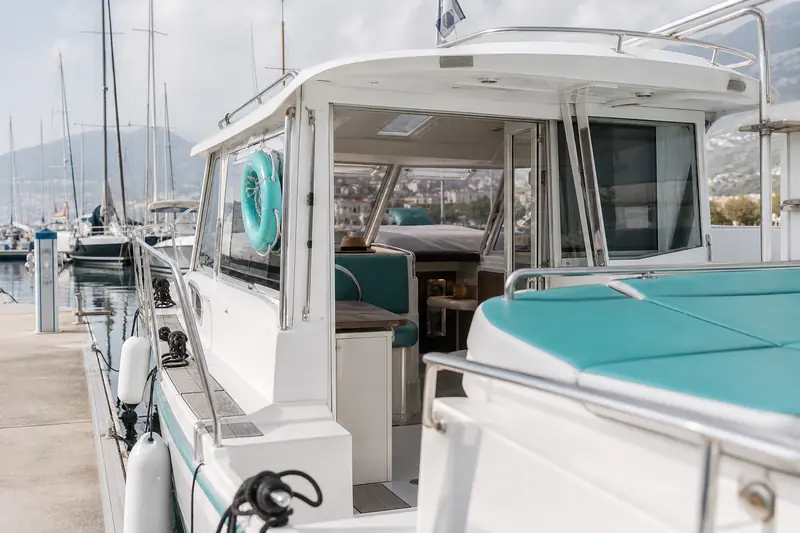 Bateau avec cabine amarré dans un port de plaisance français