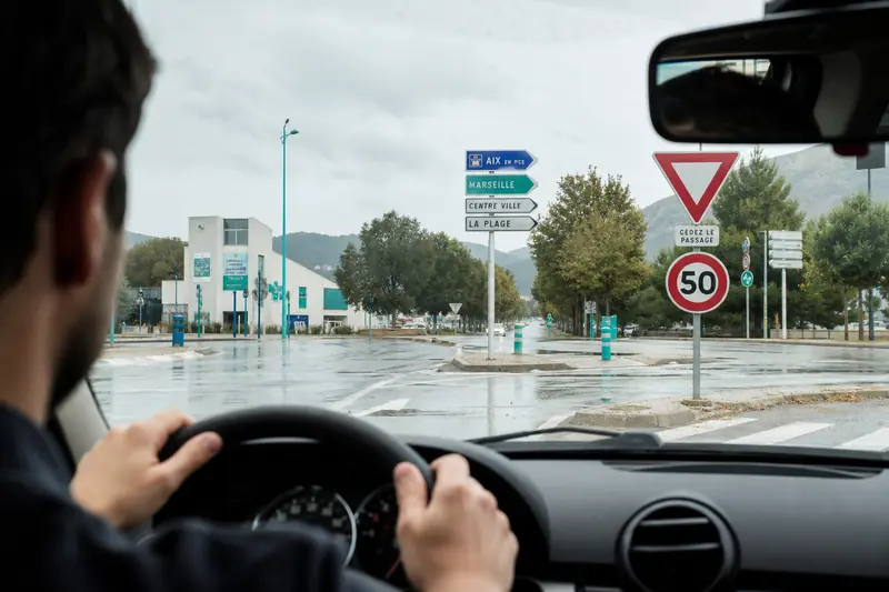 Conductrice observant des panneaux routiers à une intersection urbaine française