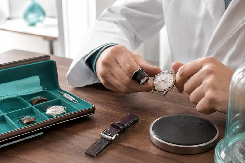 Expert examinant une montre de luxe dans une bijouterie spécialisée.