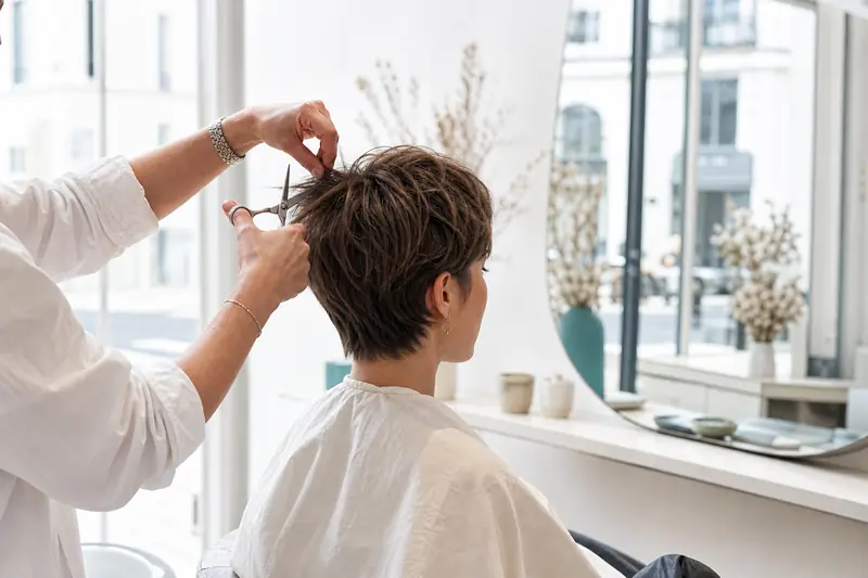 Jeune femme choisissant une coiffure courte dans un salon lumineux