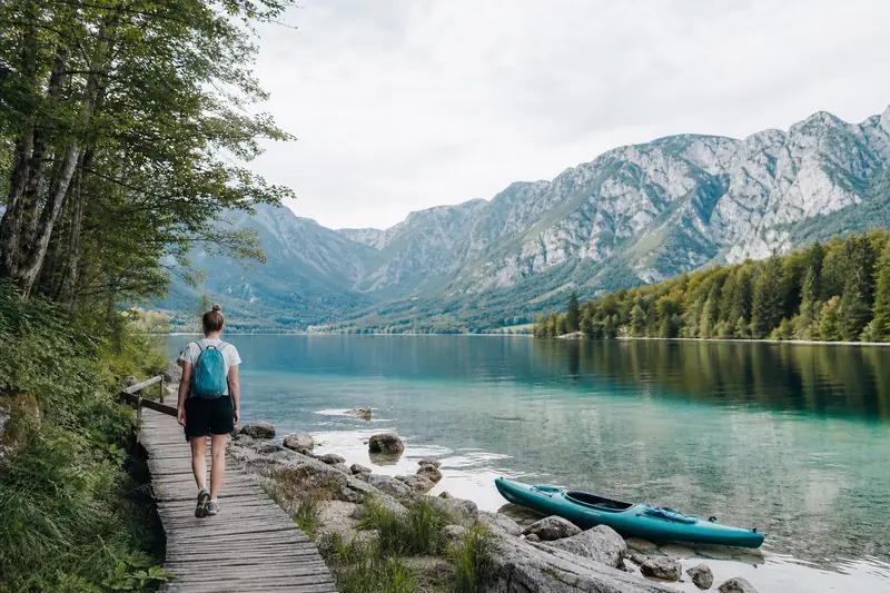 Randonneur au bord du lac Bohinj dans les Alpes slovènes au matin.