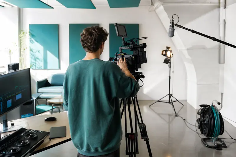 Étudiant dans une école audiovisuelle réglant une caméra dans un studio lumineux
