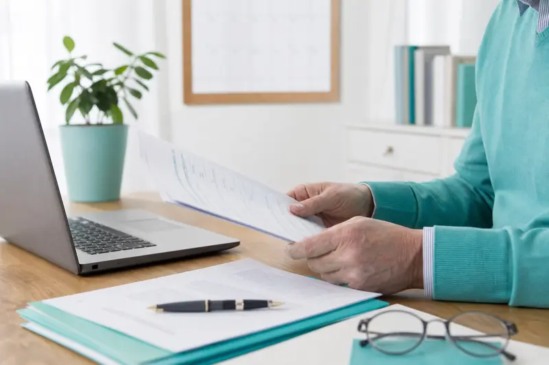 Retraité examinant les règles du cumul emploi-retraite sur son bureau.