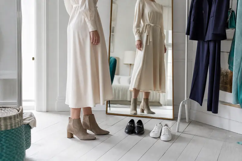 Choix de chaussures harmonisées avec un pantalon et une robe dans un dressing.