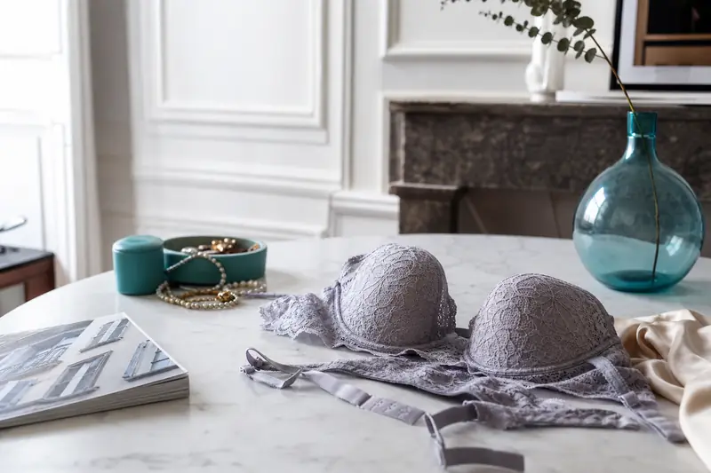 Une femme compare des pièces de lingerie aux tailles et matières différentes.
