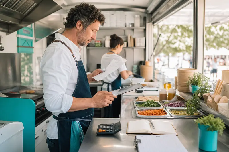 Gérant de foodtruck calculant ses coûts après une formation continue
