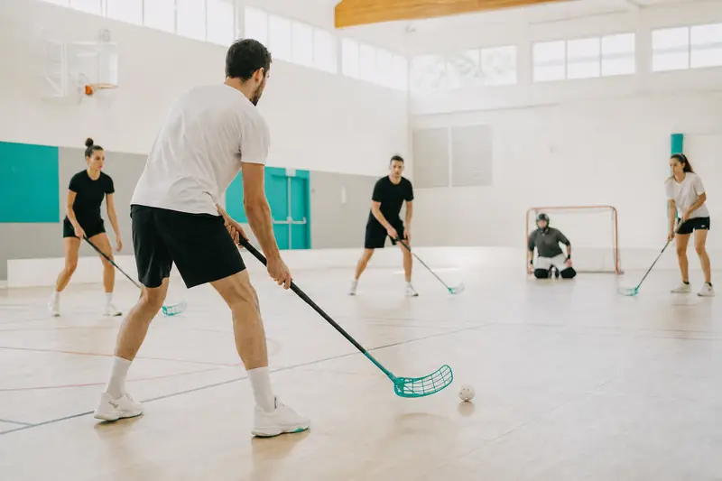 Joueurs de floorball débutants lors d’une séance en gymnase.