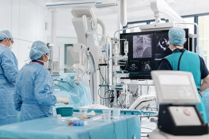 Équipe de cardiologie préparant une intervention cardiaque par cathéter en milieu hospitalier.