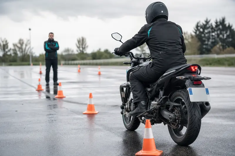 Candidat au permis moto s’exerçant au freinage sur une piste.
