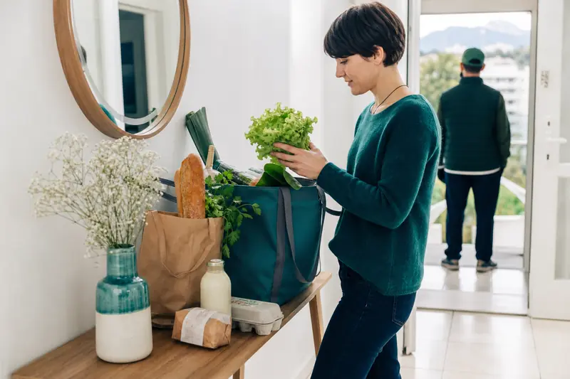 Réception d’une livraison de courses dans l’entrée d’un appartement à Grenoble