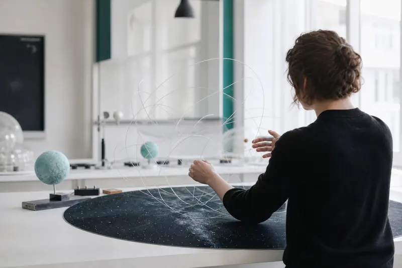 Modèles de cordes transparentes illustrant la théorie des supercordes sur une table de physique.