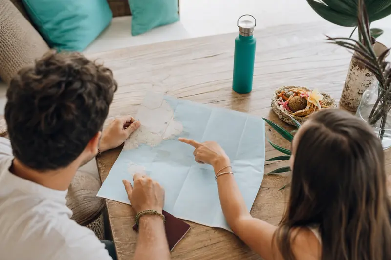 Voyageurs préparant un itinéraire de voyage à Bali sur une table.