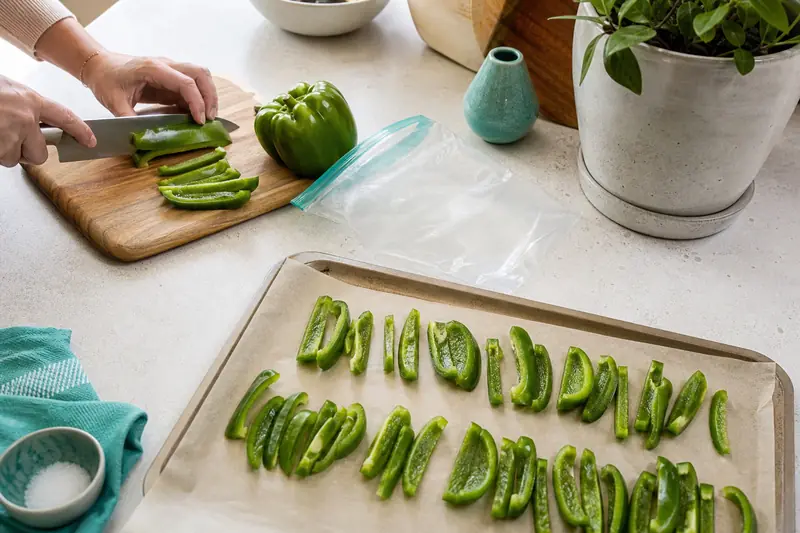 Poivrons verts crus découpés sur plaque avant congélation maison