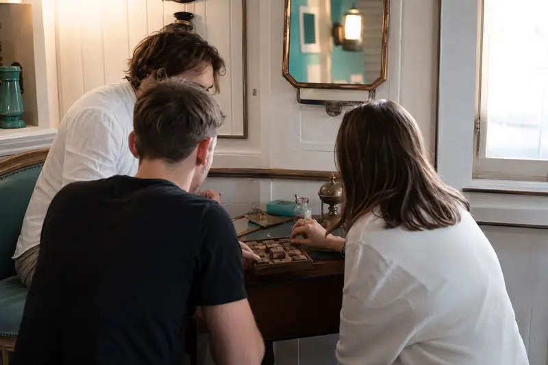 Joueurs résolvant des énigmes dans un escape game au décor soigné
