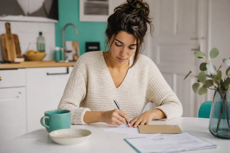 Locataire qui prépare une lettre de préavis et des documents sur une table