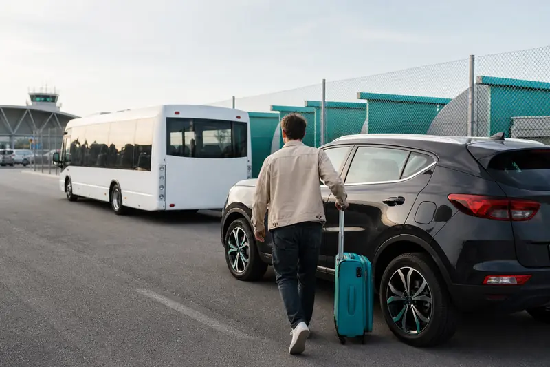 Voyageur déposant ses bagages dans un parking aéroport sécurisé avec navette