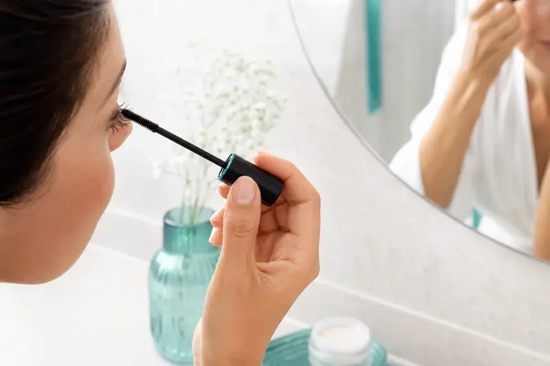 Application d’un mascara anti-transfert sur une paupière de peau grasse.