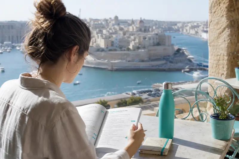 Étudiante préparant un séjour linguistique à Malte face au port méditerranéen