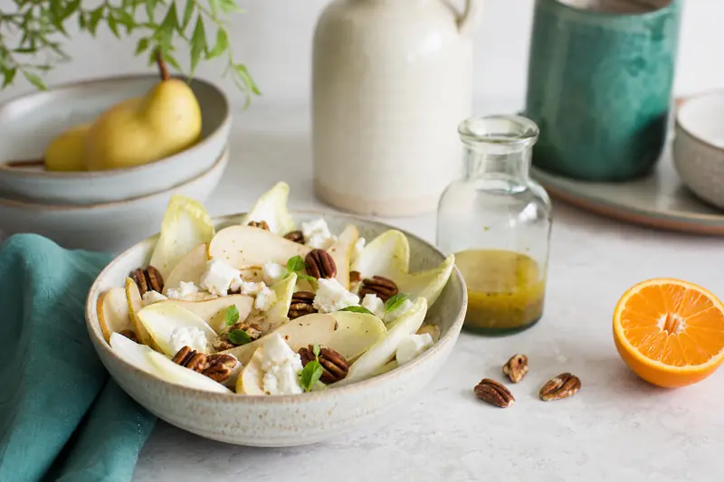 Noix de pécan avec poire, chèvre et endives dans une salade