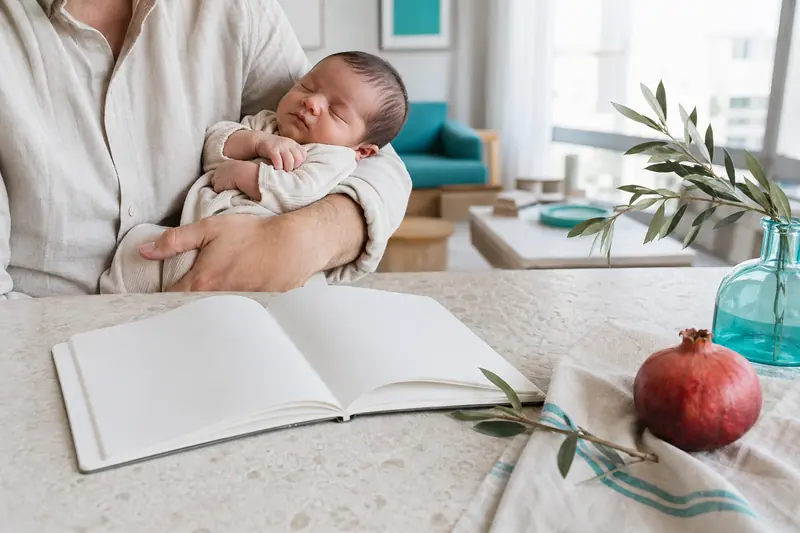 Parents choisissant des prénoms israéliens près d’un nouveau-né dans un intérieur lumineux