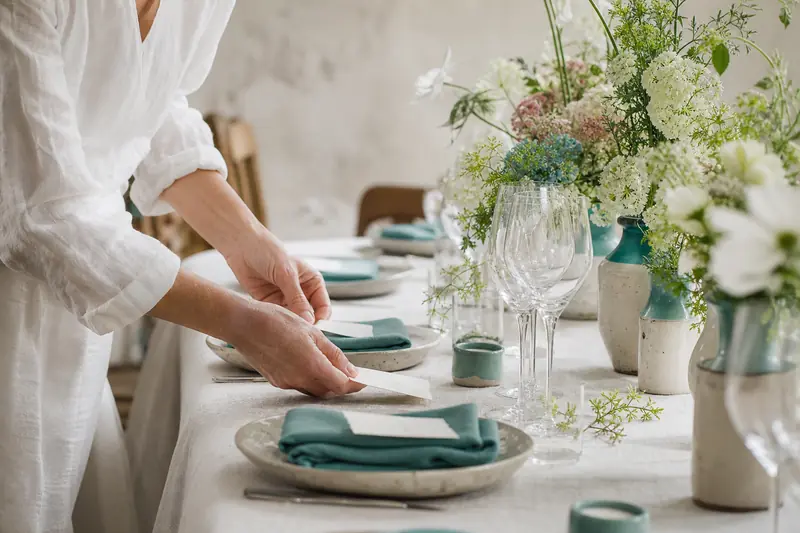 Table de mariage artisanale avec céramiques, fleurs locales et papeterie faite main.