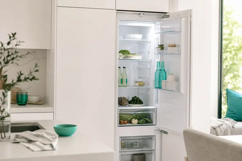 Réfrigérateur blanc encastrable dans une cuisine moderne et lumineuse
