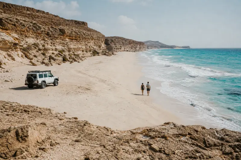 Plage sauvage de Salalah bordée de falaises sur la côte sud d’Oman