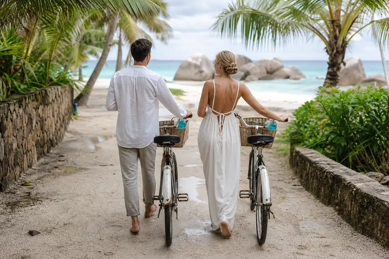 Couple à vélo sur La Digue lors d’une lune de miel écologique.