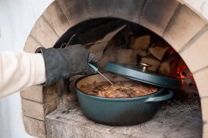 Cocotte de viande en cuisson lente dans un four à bois