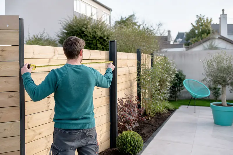 Mesure d’une clôture de jardin en bois et métal sur terrain plat